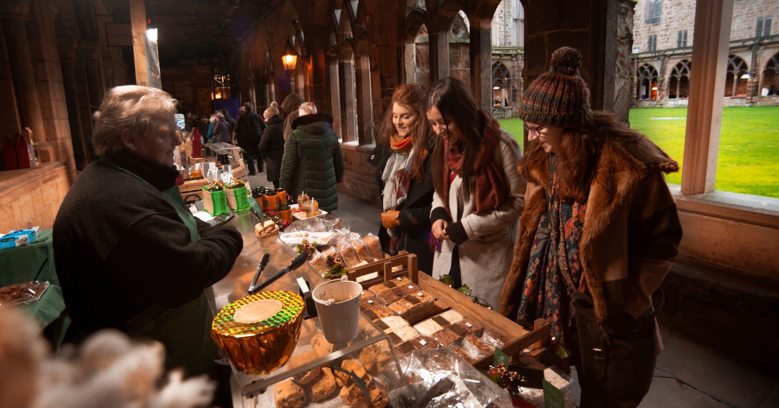 group of woman admiring a market stall at the Christmas Market in Durham Cathedral cloisters 